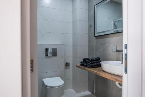 a bathroom with a white toilet and a sink at Home Art Apartments in Skopje