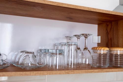 a shelf with glass jars and bowls on it at Home Art Apartments in Skopje