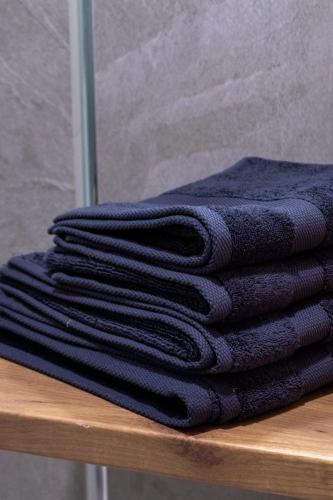 a stack of black towels sitting on a table at Home Art Apartments in Skopje