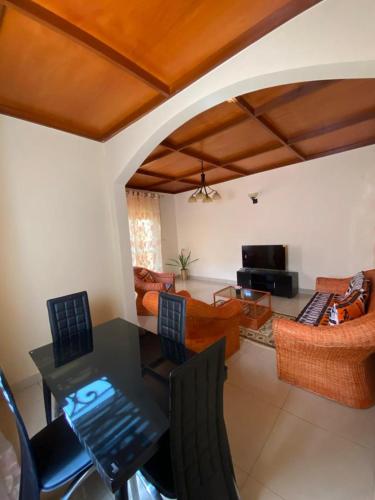 een woonkamer met een tafel en stoelen en een bank bij Hill Residence in Yaoundé