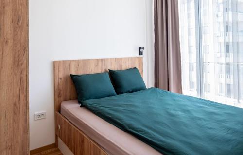 a bed with a wooden head board and a window at Home Art Apartments in Skopje