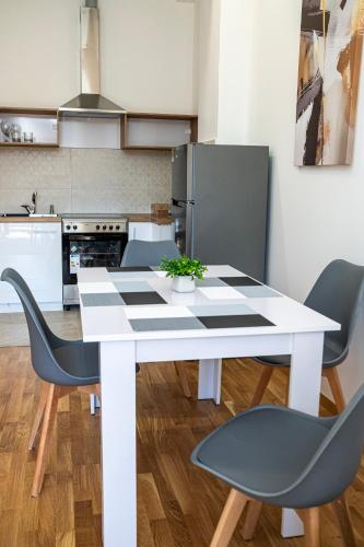 a white table and chairs in a kitchen at Home Art Apartments in Skopje
