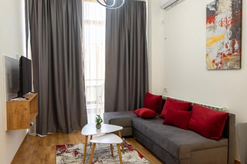a living room with a gray couch and red pillows at Home Art Apartments in Skopje