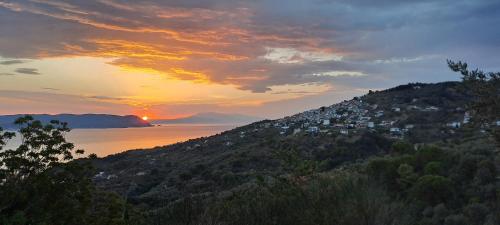 a sunset over a hill with houses on it at BLUE, Traditional House in Klíma