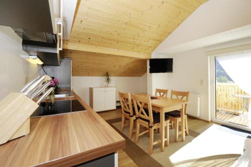 a kitchen and dining room with a table and chairs at Aktiv-Ferienwohnungen Montafon in Sankt Gallenkirch