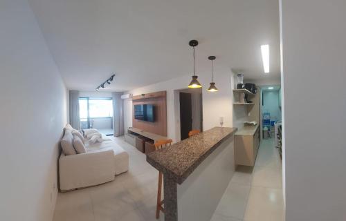 uma cozinha e sala de estar com um sofá e uma mesa em Apartamento Novo em Ondina em Salvador