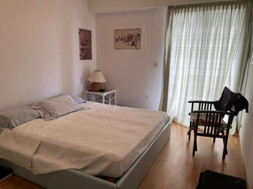 une chambre avec un lit, une chaise et une fenêtre dans l'établissement Front sea Luxury, à Cagnes-sur-Mer