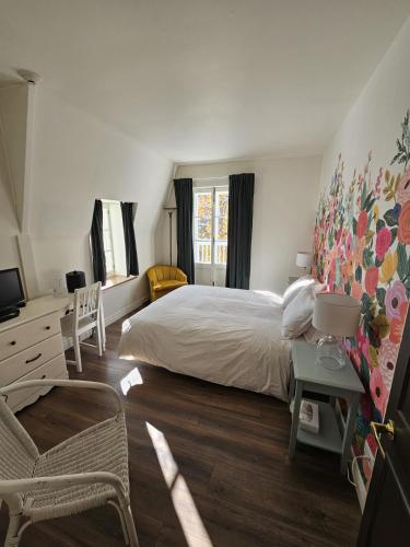 a bedroom with a bed and a desk and a television at Auberge La Marmite in La Malbaie