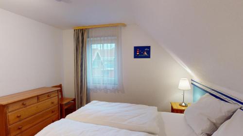 - une chambre avec un lit et une fenêtre dans l'établissement Ort Lemkenhafen Segler, à Fehmarn