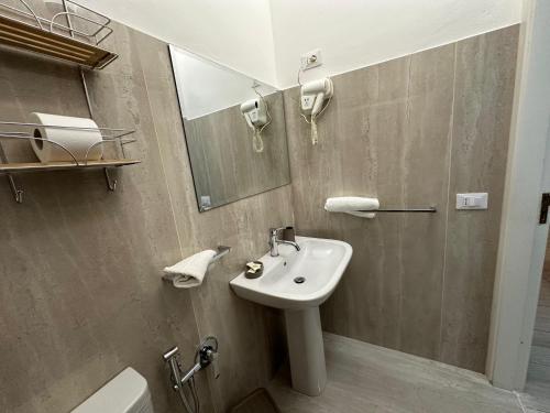 a bathroom with a sink and a mirror and a toilet at Affittacamere Resalibera in Siracusa