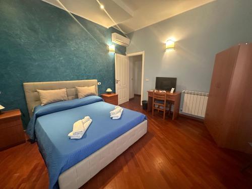 a bedroom with a bed with blue sheets and a desk at Affittacamere Resalibera in Syracuse