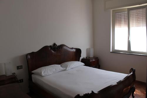 a bedroom with a bed with white sheets and a window at Smile At Vesuvio in Naples