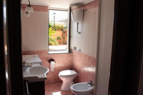 baño con aseo y lavabo y ventana en Smile At Vesuvio, en Nápoles