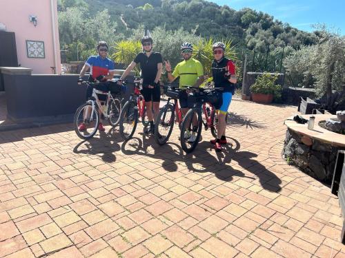 un grupo de cuatro personas de pie con sus bicicletas en la Tana di Luna, en Adrano