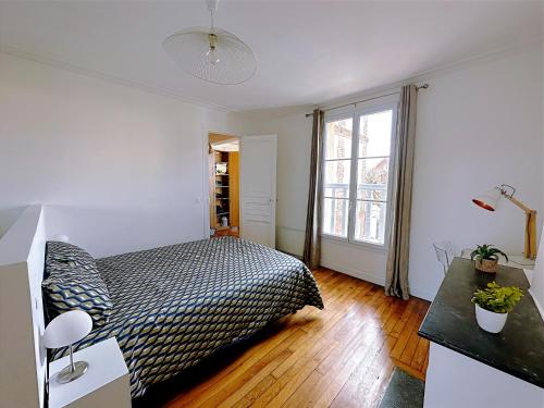 ein Schlafzimmer mit einem Bett und einem großen Fenster in der Unterkunft Cerise - L'escale Paris Orly Airport in Choisy-le-Roi