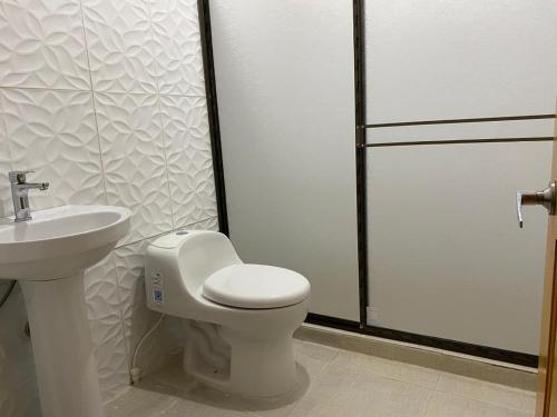La salle de bains est pourvue de toilettes et d'un lavabo. dans l'établissement Amazon Açaí Lodge, à Leticia