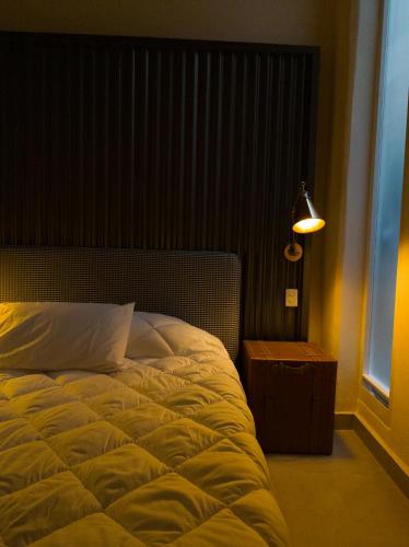 a bedroom with a bed and a lamp and a window at WUER Expiatorio in León