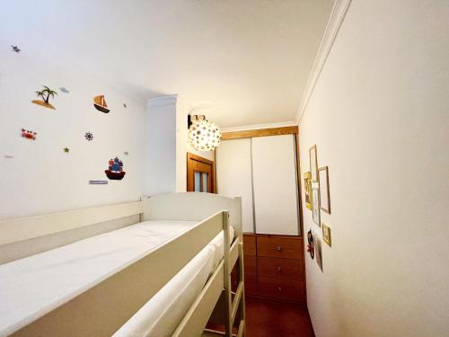 a small bedroom with a bed and a hallway at Lua do Mar in Caniço