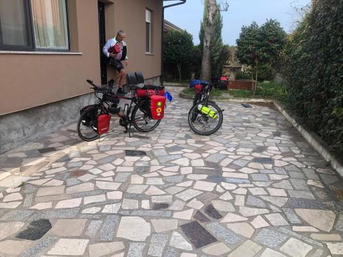 a man standing next to two bikes parked on a patio at B&B Villa lucia in SantʼEufemia Lamezia