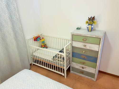 a crib and a dresser in a bedroom at Lua do Mar in Caniço