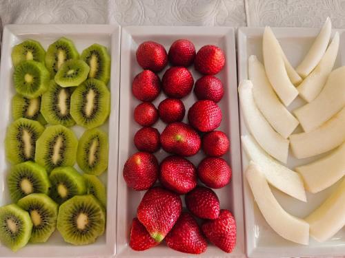 deux récipients en plastique remplis de fraises et de kiwis et de fruits en tranches dans l'établissement Casa Turchetti, à Taormine