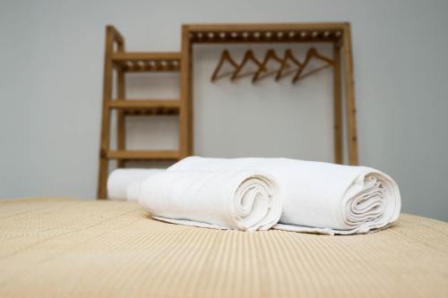 stos białych ręczników siedzących na łóżku w obiekcie Villa Capri-Kaprovani w mieście Shekhvetili