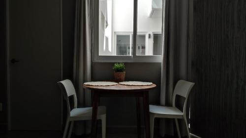 a table with a potted plant on it in a window at WUER Expiatorio in León