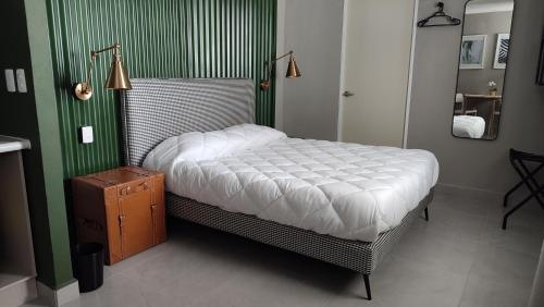 a bed in a room with a green wall at WUER Expiatorio in León