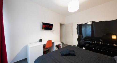 a bedroom with a bed and a tv and a desk at Corte ‘e susu in Nuoro