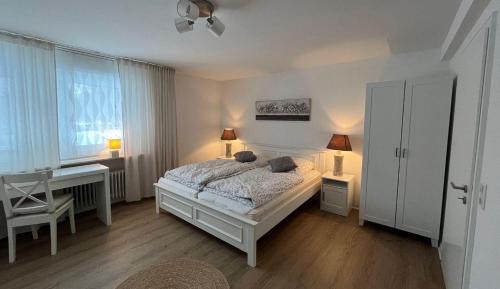 Schlafzimmer mit einem Bett, einem Schreibtisch und einem Fenster in der Unterkunft Landhus-Sylt  in Archsum