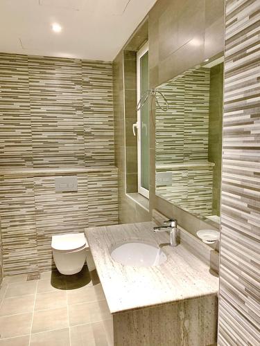 Iveria Hotel Apartments في هيل العمير: حمام مع حوض ومرحاض