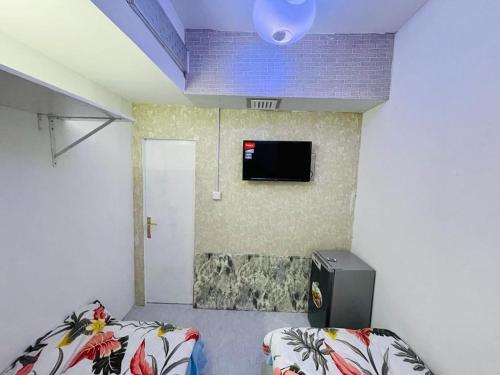 a room with two beds and a tv on a wall at Amazing couples Partition 7 min walking from Mall of emirates in Dubai