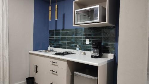 a kitchen with a sink and a microwave at WUER Expiatorio in León
