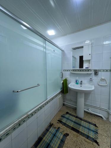 a white bathroom with a sink and a shower at Bab Ezzouar in Bab Ezzouar