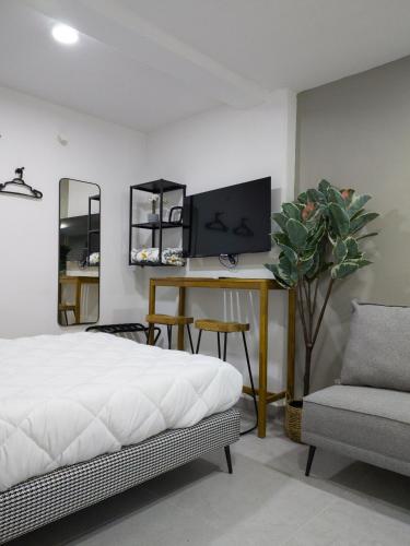 a bedroom with a bed and a tv and a chair at WUER Expiatorio in León