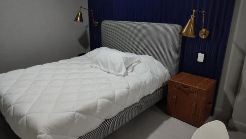 a bedroom with a white bed and a brown suitcase at WUER Expiatorio in León