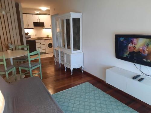 a living room with a tv and a dining room at Apartamento En Camino - Milladoiro in Milladoiro