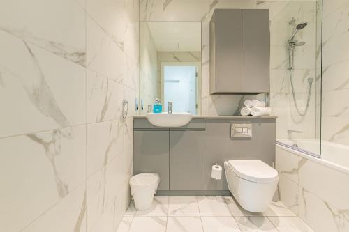 La salle de bains blanche est pourvue de toilettes et d'un lavabo. dans l'établissement The Cornerstone One by Dublin At Home, à Dublin