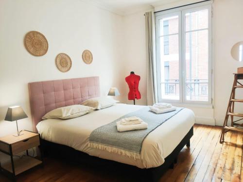 une chambre avec un lit et une grande fenêtre dans l'établissement Charmant appartement au pied d'un parc arboré, à Clichy