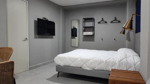 a bedroom with a bed and a tv on the wall at WUER Expiatorio in León