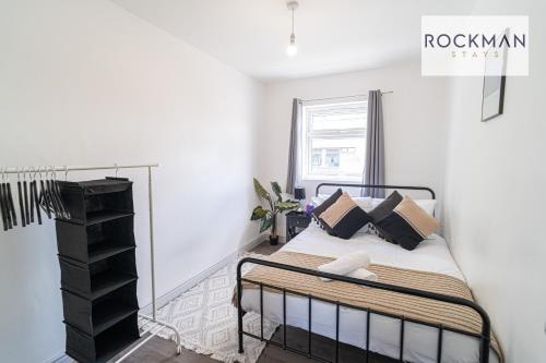 um quarto com uma cama num quarto branco em 10A Cromwell Road - Elegant & Modern 3 Bedroom Apartment in Central Grays with 5 beds em Grays Thurrock