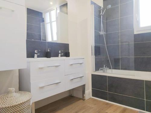 une salle de bain avec un lavabo, une baignoire et une douche dans l'établissement Charmant appartement au pied d'un parc arboré, à Clichy