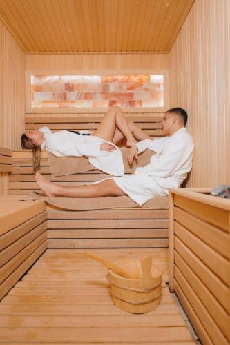 a man and woman sitting in a sauna at Privat Studio Milmari in Kopaonik