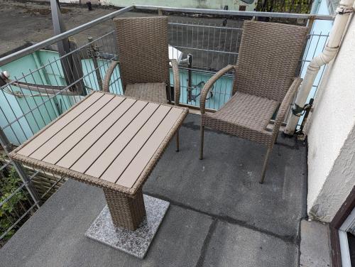 2 krzesła i drewniana ławka na balkonie w obiekcie Studio 1 w Bremie