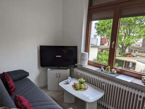 a living room with a couch and a tv and a table at Studio 1 in Bremen