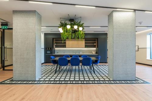 a dining room with blue chairs and a table in a building at The Cornerstone Two by Dublin At Home in Dublin