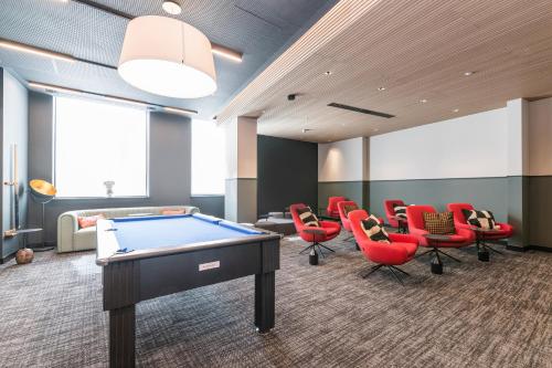 a billiard room with red chairs and a pool table at The Cornerstone Two by Dublin At Home in Dublin