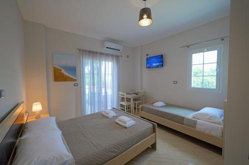 1 dormitorio con 2 camas y ventana en Hotel Deja Vu en Ksamil