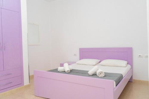 a bedroom with a purple bed with towels on it at Vila Anxhelo in Vlorë
