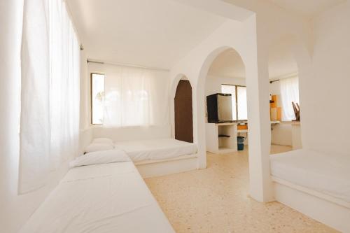 a white room with two beds and a tv at Hotel Bungalows Marbella Costa Esmeralda in Monte Gordo